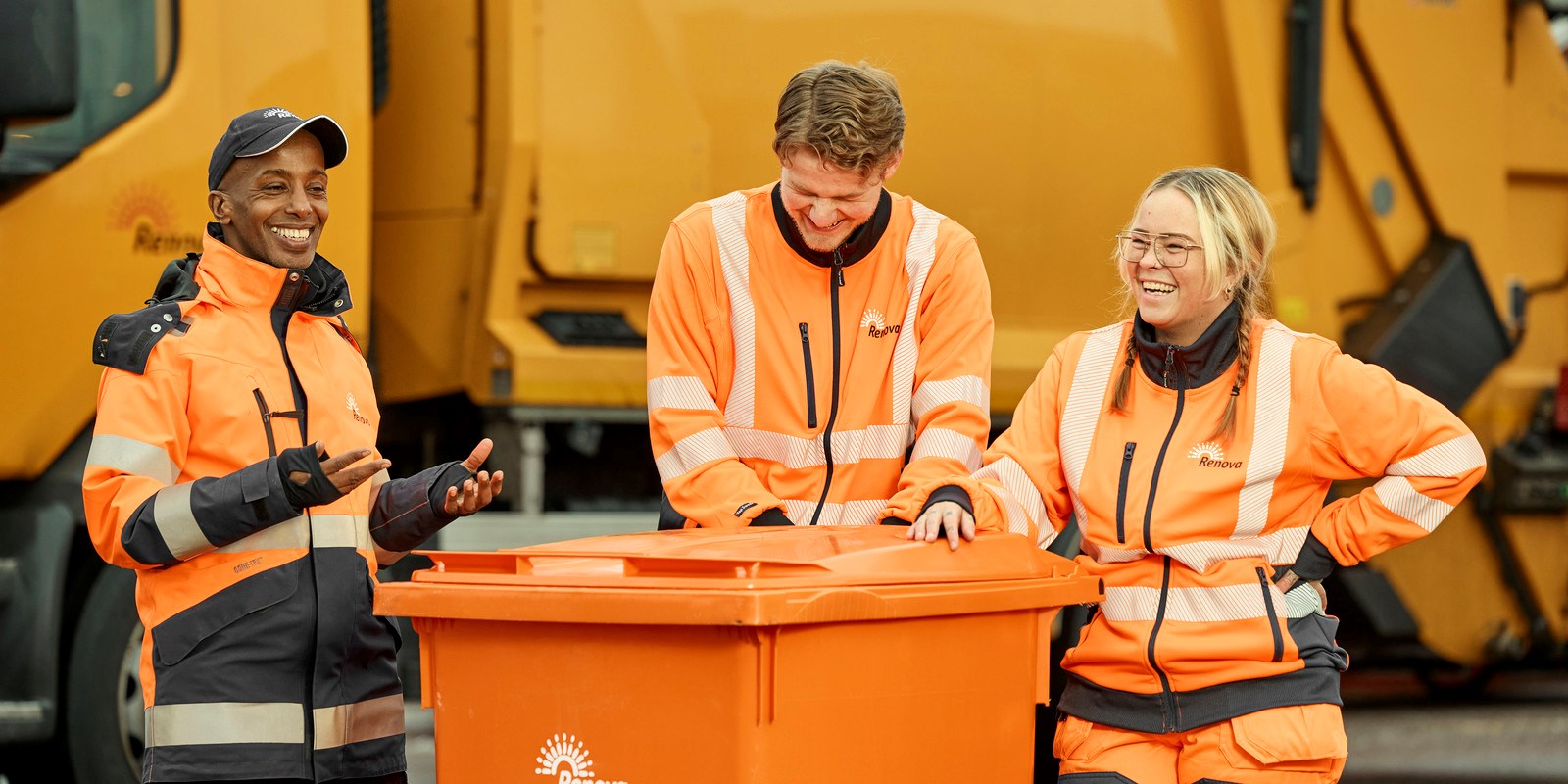 Människor i orange kläder som står och lutar sig mot ett kärö